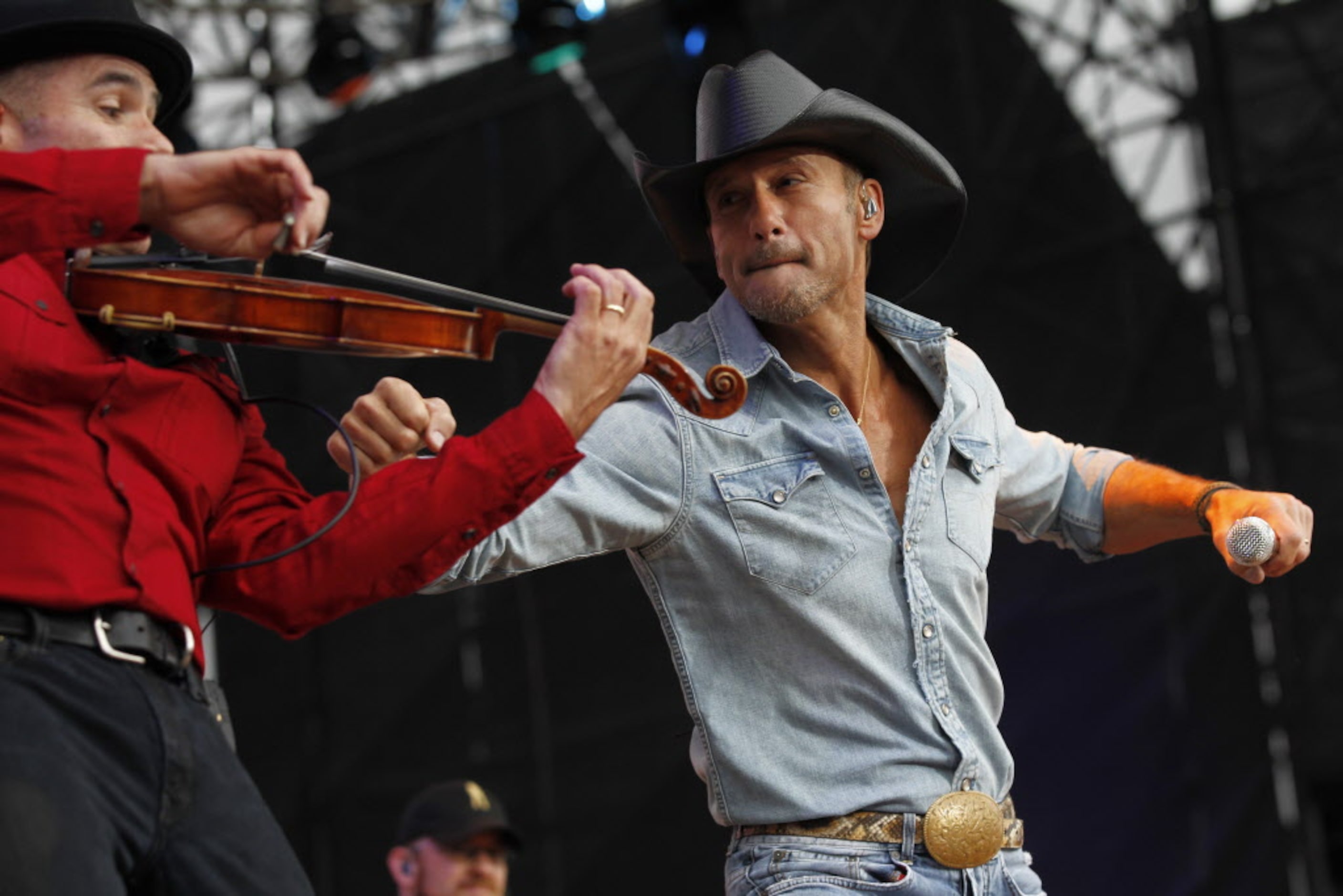 Tim McGraw play punches his violinist in the arm during his performance at the March Madness...