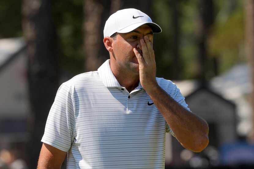 Scottie Scheffler reacts after missing a putt on the second hole during the second round of...