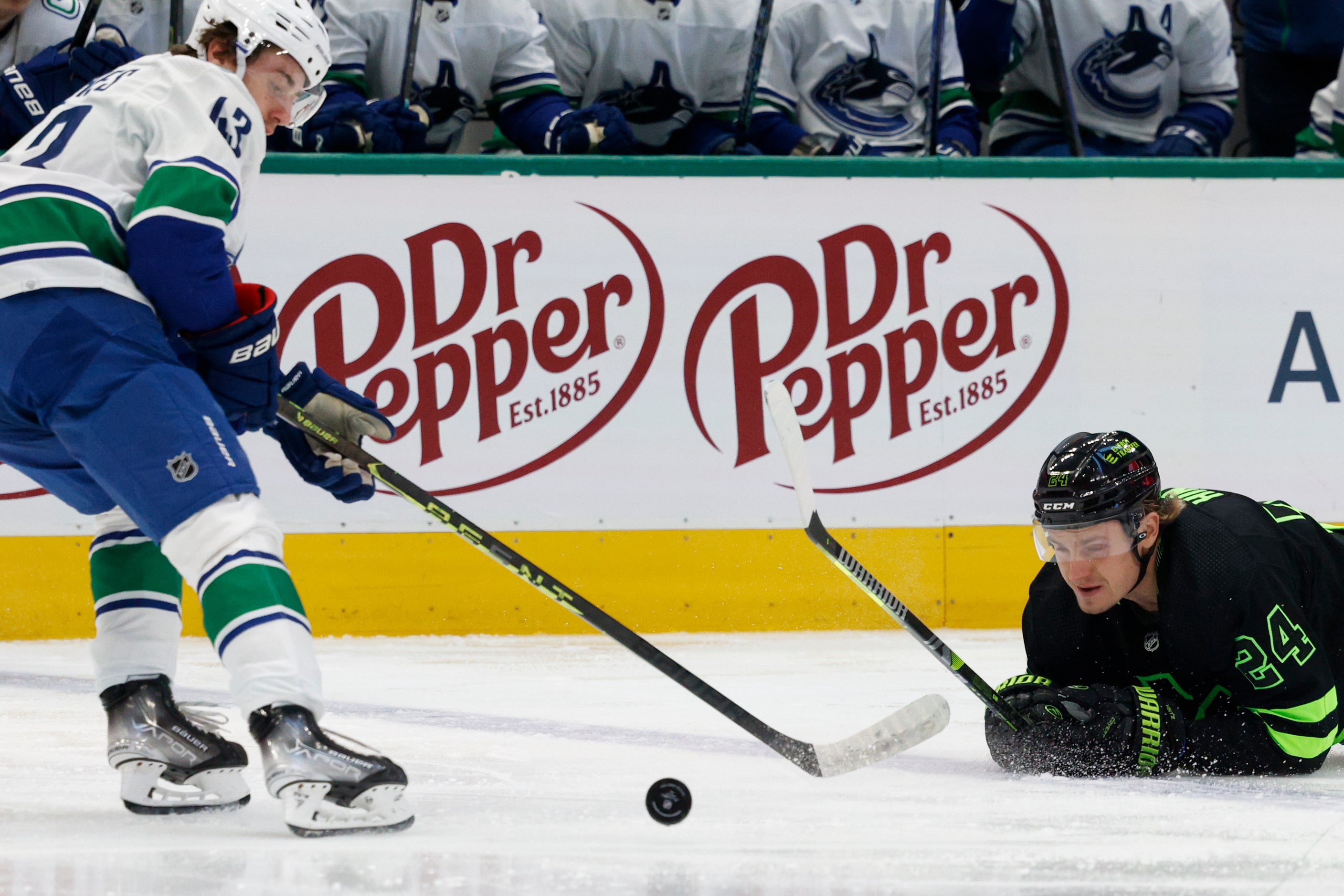 Dallas Stars center Roope Hintz (24) falls to the ice while chasing the puck alongside...