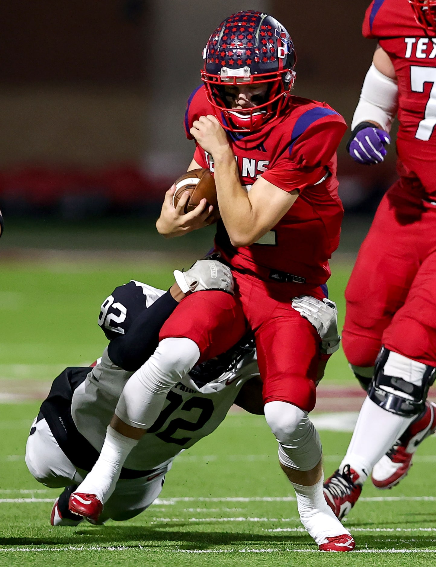 Justin Northwest quarterback Ryder Norton (11) is dragged down by Trinity defensive lineman...