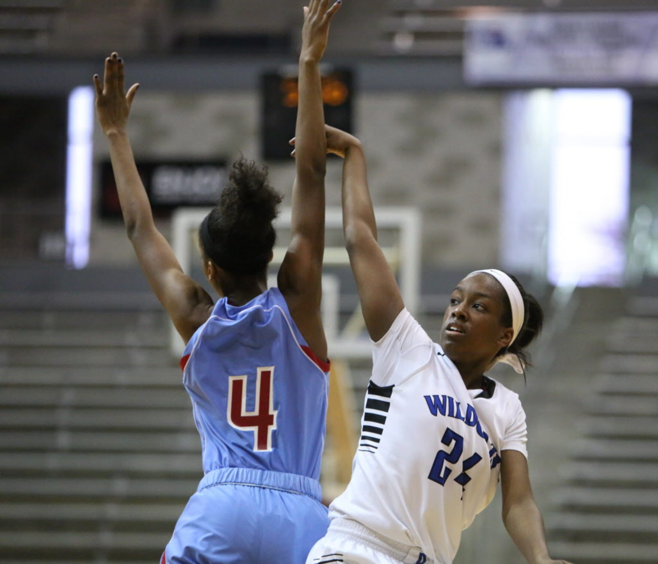 Dekaney's Lauren Grigsby (right) shoots a three pointer over Skyline guard Raven Johnson...