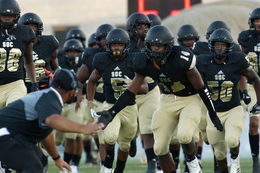 South Oak Cliff defensive lineman Steven Parker (14) is joined by teammates as the Golden...