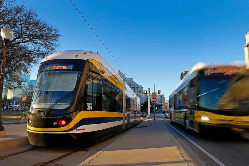 A DART bus passes by the Dallas Streetcar at Reunion Station Stop in Dallas, Tuesday, Jan....