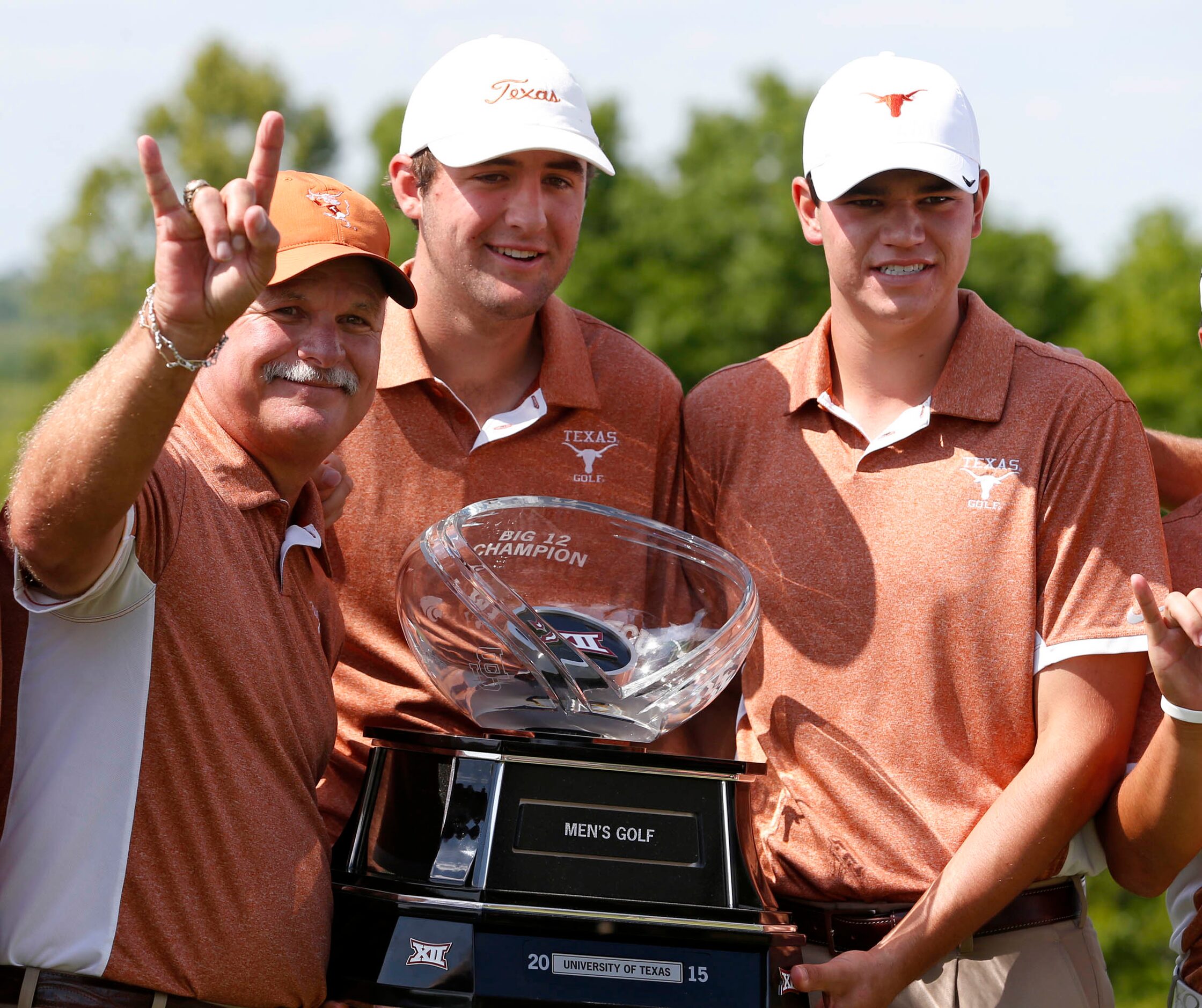 Texas' coach John Fields, left, celebrates with Scottie Scheffler, center, and Beau Hossler...