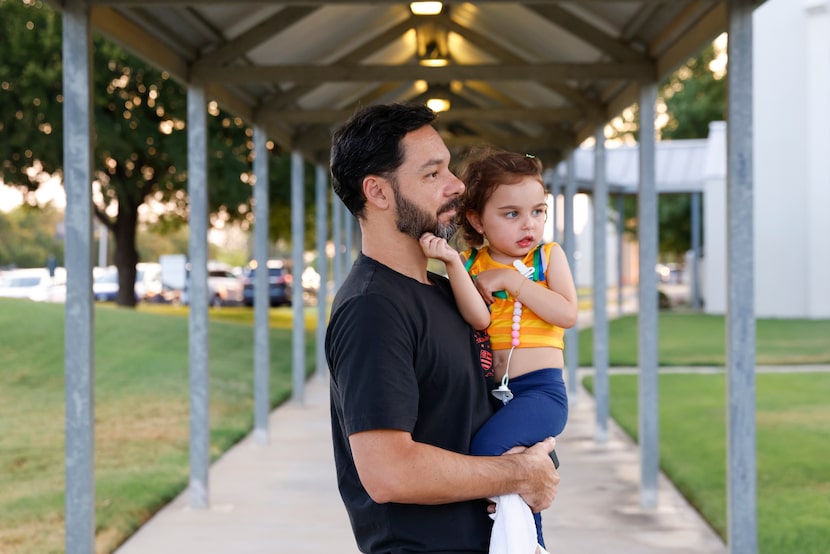 Rafael Alves stood with his daughter Louise, 4, during the memorial service of Julio...