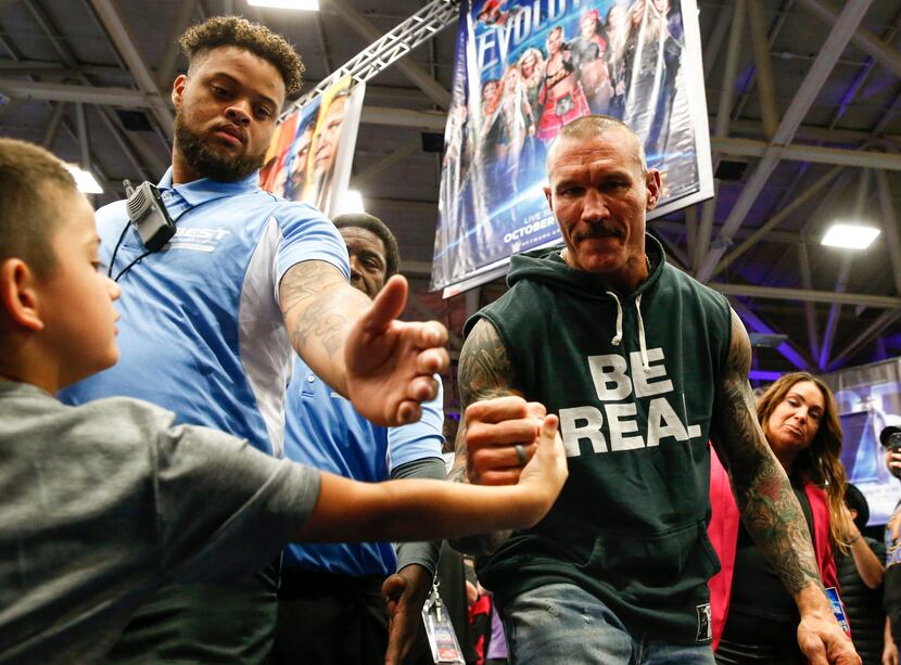 Derek Garcia, 6, from Dallas, gets a fist bump from WWE superstar Randy Orton during an...