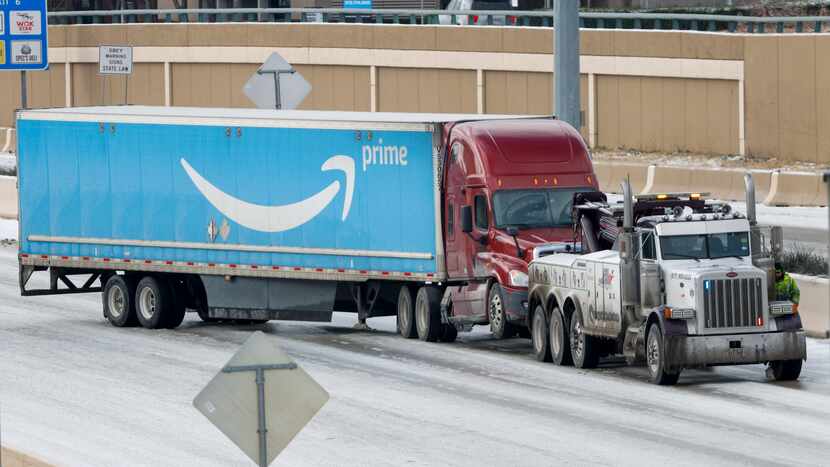 A tow truck works to clear a disabled Amazon tractor-trailer on northbound U.S. Highway 75...