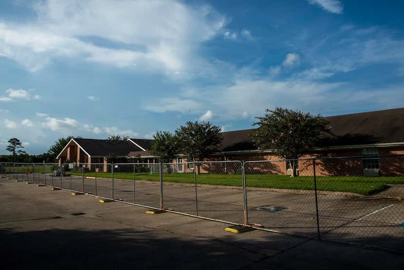 A fence surrounds the vacant Cypress Glen nursing home on Monday in Port Arthur.  The Texas...