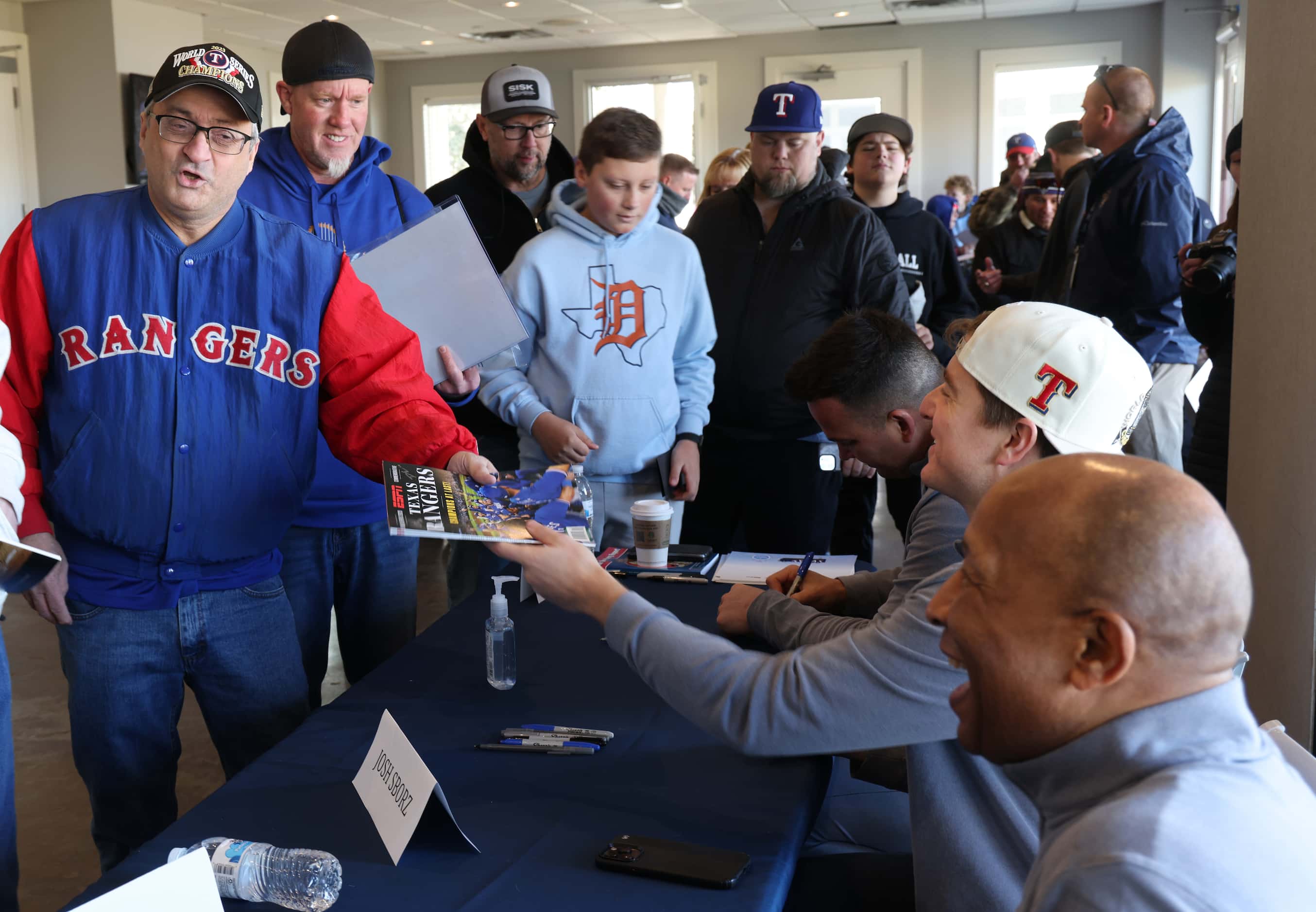 Texas Rangers fan Peter Munoz, left, from Carrollton, reacts after receiving an autograph...