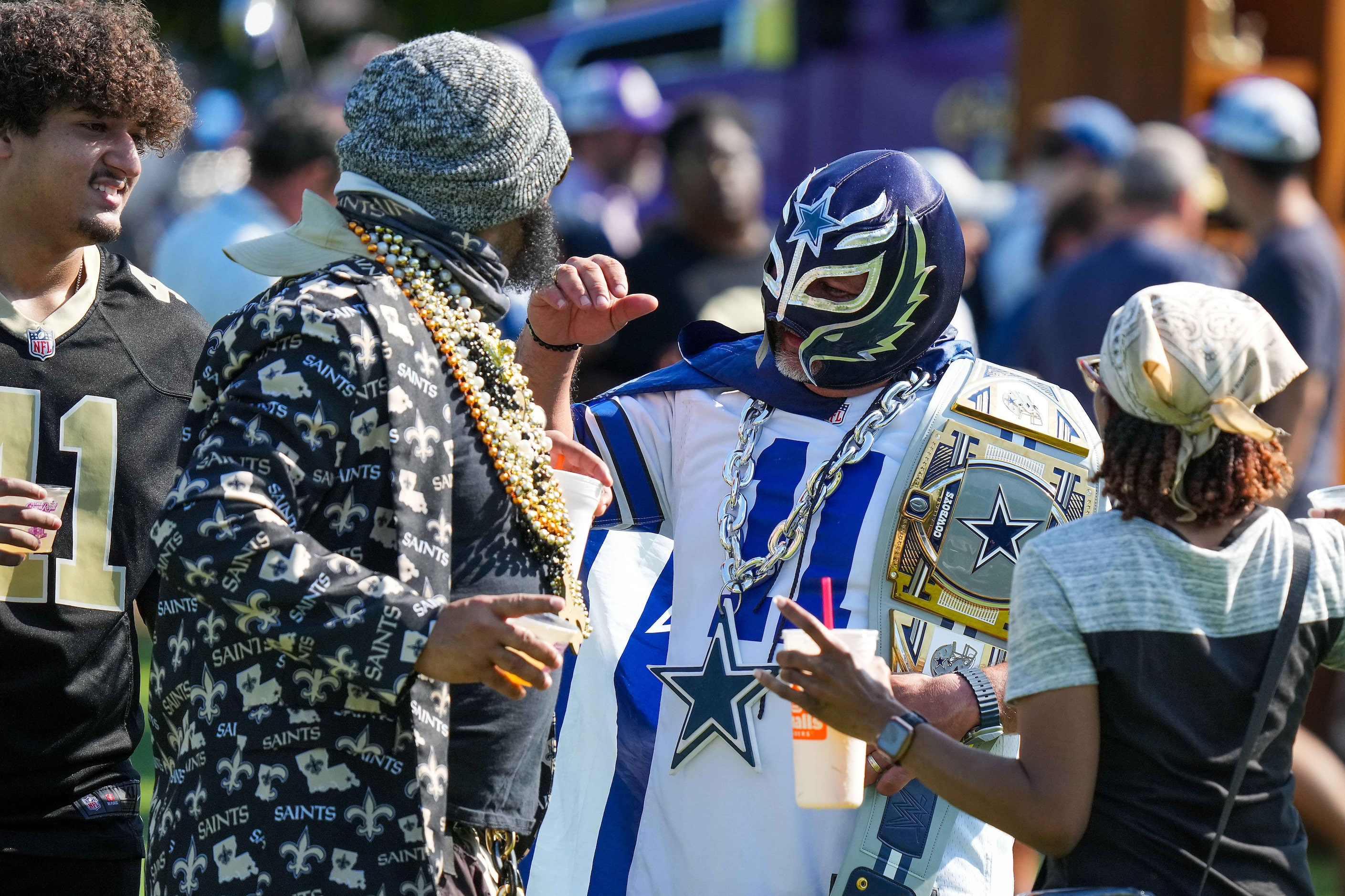 Dallas Cowboys fan Jesse Montez of San Antonio laughs with New Orleans Saints fans as they...