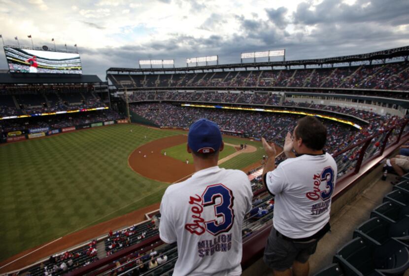 Rangers fans Chad and Kent Gilley of Azle were among the 36,102 spectators who pushed the...