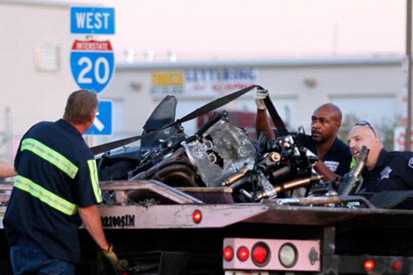 Wreckers tied down a motorcycle to be hauled away after a fatal 2011 accident on I-20 near...