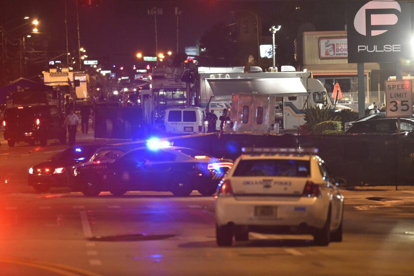  Lights from police vehicles light up the scene in front of the Pulse club in Orlando,...