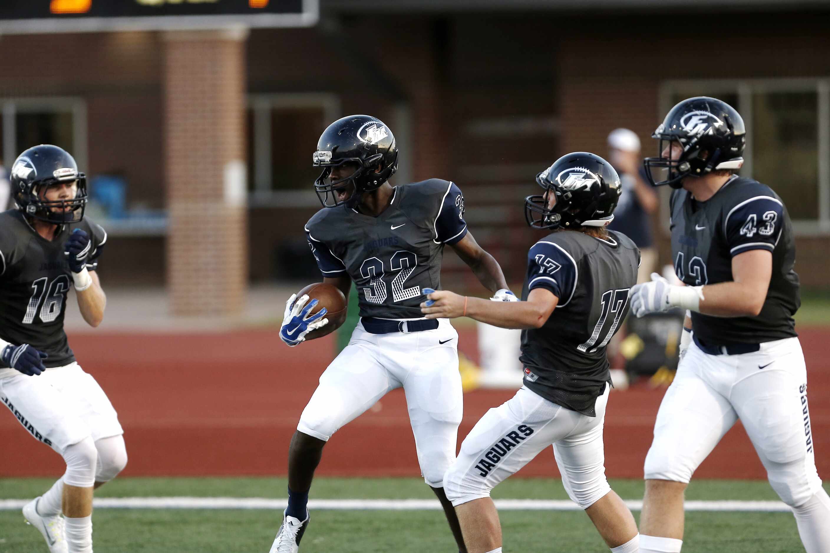 Flower Mound junior running back Ifeanyi Uzowihe (32) is congratulated by teammates after...