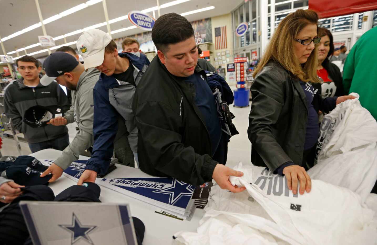 Cowboys fans buy the Cowboys NFC East Champion t-shirts at Academy Sports & Outdoors in...