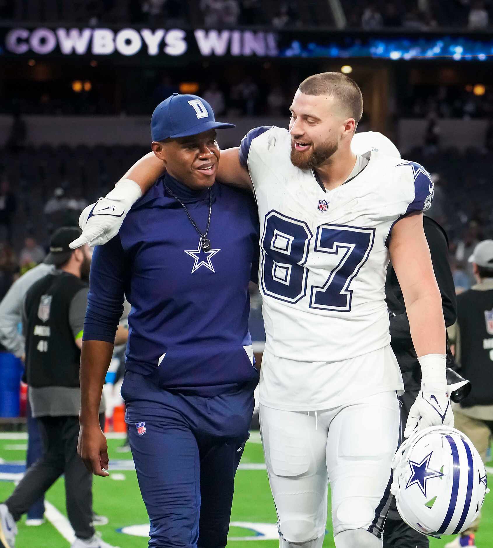 Dallas Cowboys tight end Jake Ferguson (87) puts his arm around tight ends coach Lunda Wells...