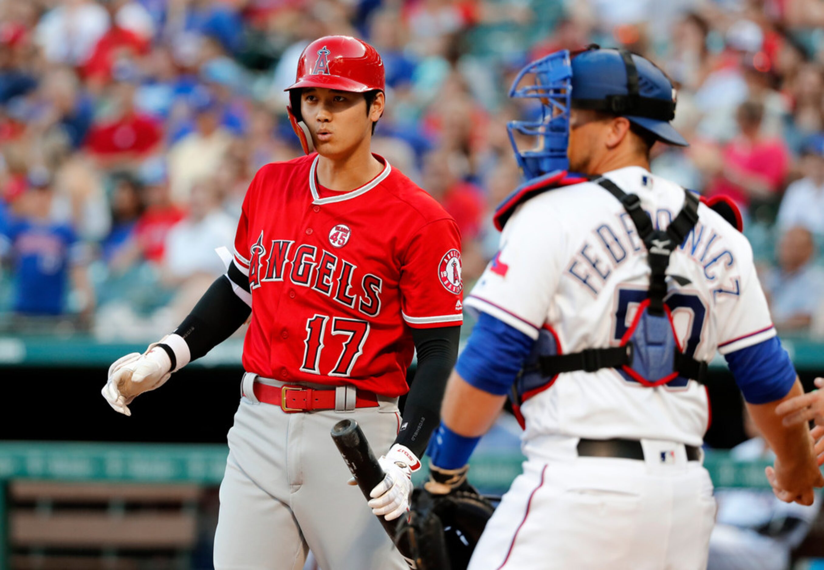 Los Angeles Angels' Shohei Ohtani watches his foul ball as Texas Rangers' Tim Federowicz...