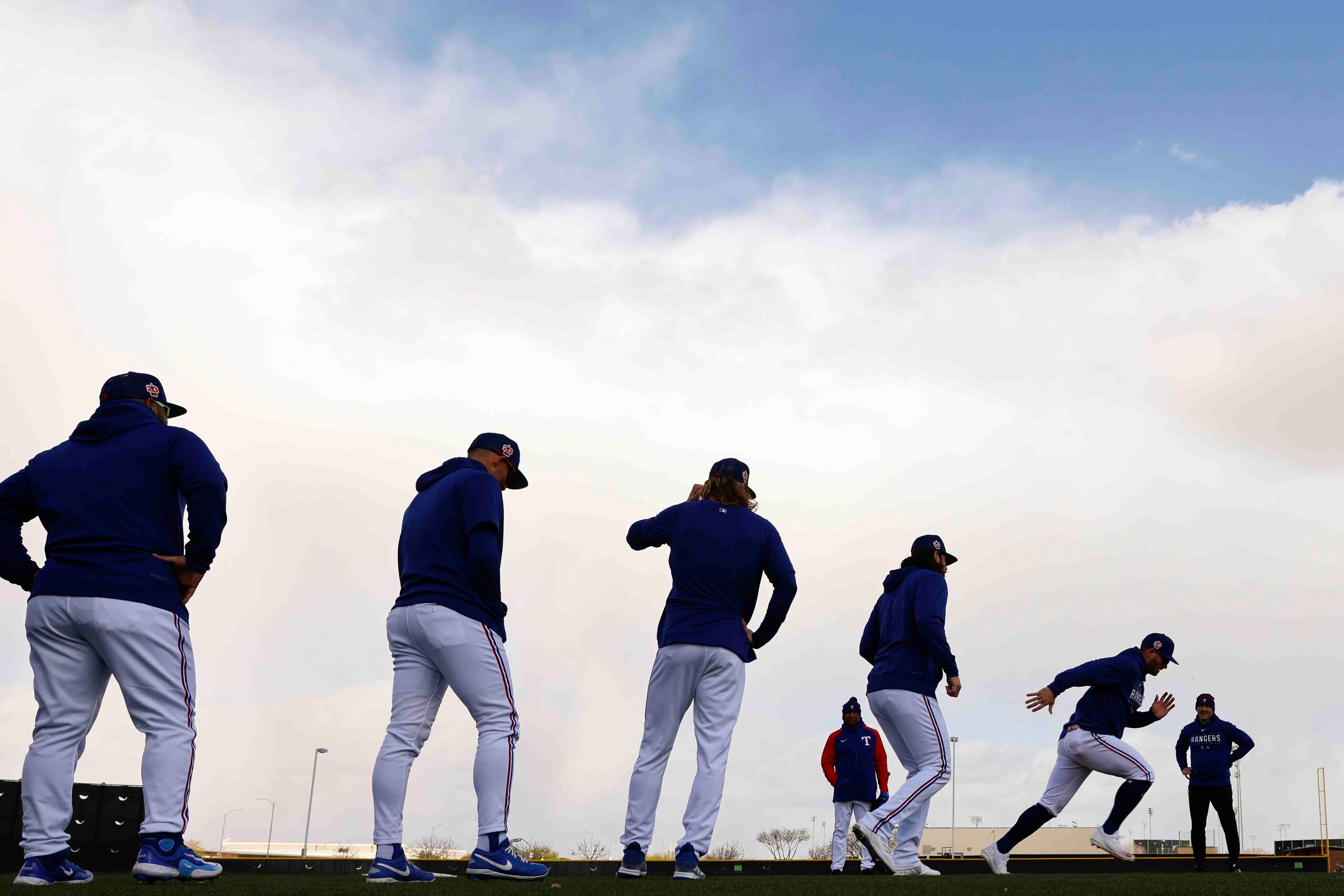 Texas Rangers players line up to run bases during a spring training workout at the team's...