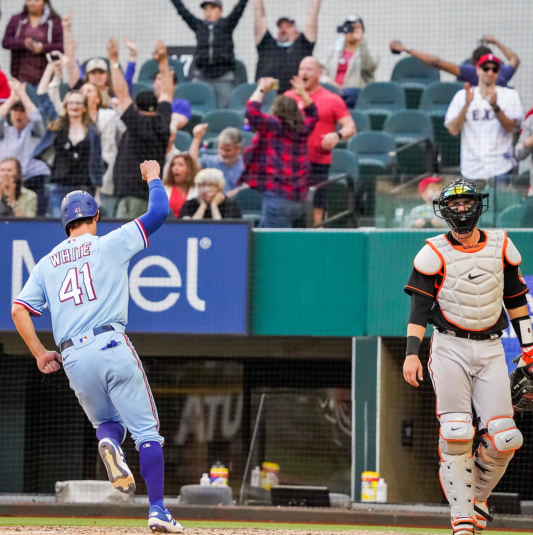 Texas Rangers outfielder Eli White scores from third base on a walk-off single by first...