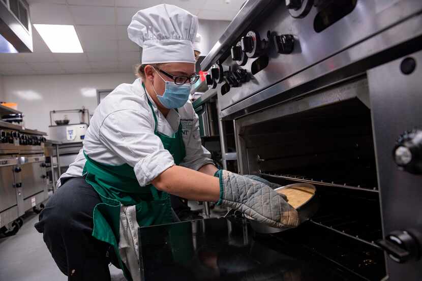 Junior Grace Harrison removes a genoise from the oven at the University of North Texas'...