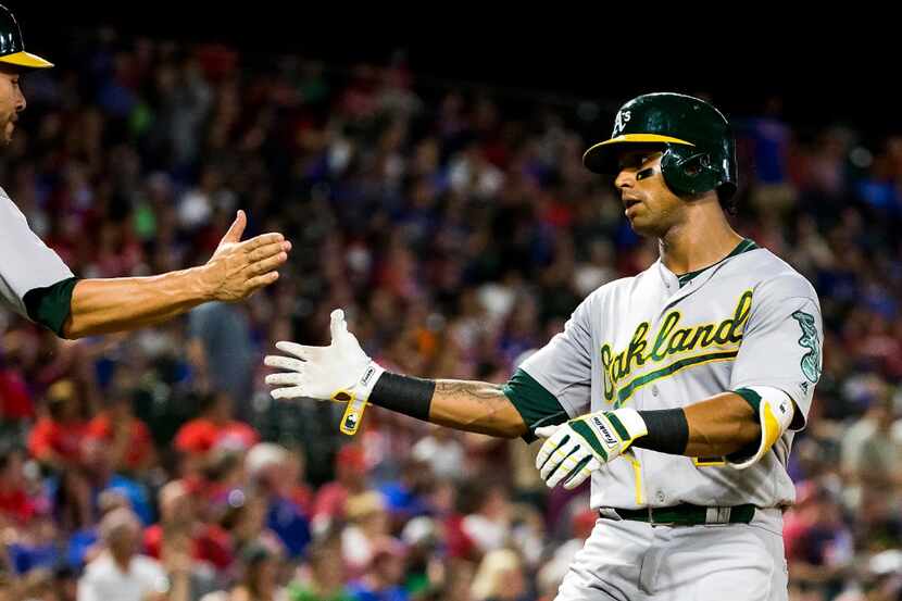 Oakland Athletics left fielder Khris Davis gets a hand from third baseman Danny Valencia...