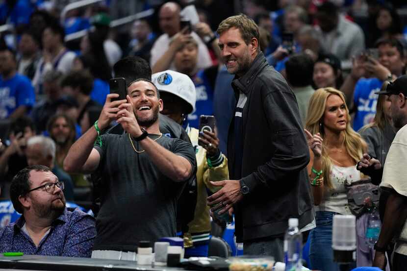 A fan takes a photo with former Dallas Maverick Dirk Nowitzki, right, before Game 1 of an...