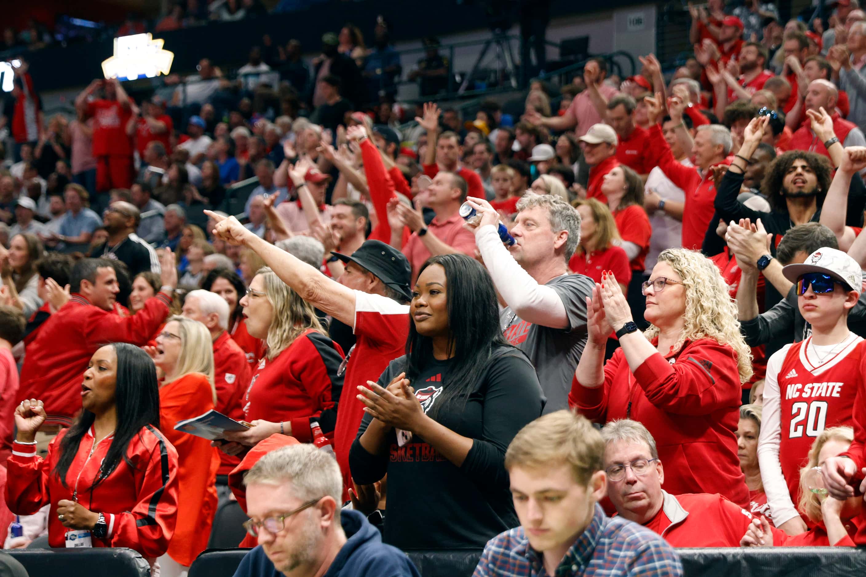 North Carolina State fans cheer during the first half of an NCAA Men’s Sweet 16 basketball...