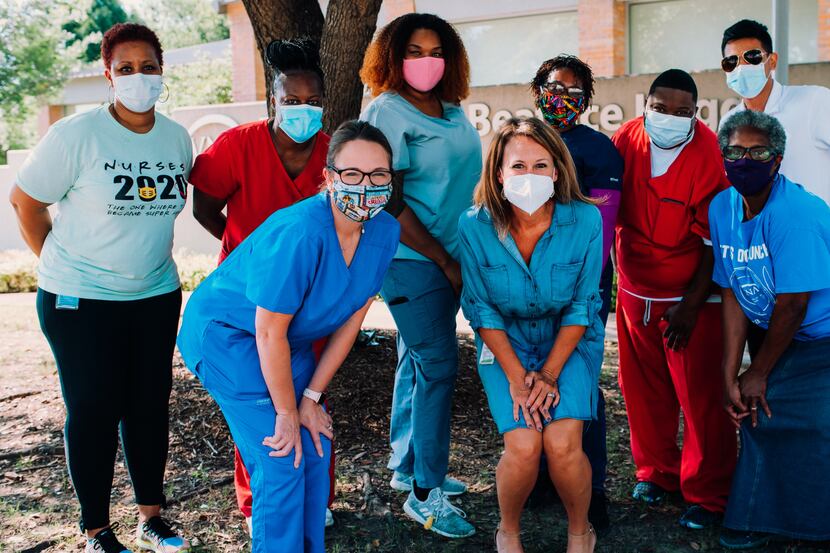 A group of nurses wearing masks pose together.