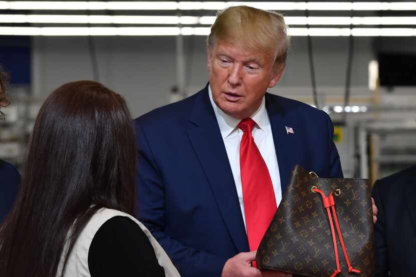 US President Donald Trump holds a bag during a visit to the new Louis Vuitton factory in...