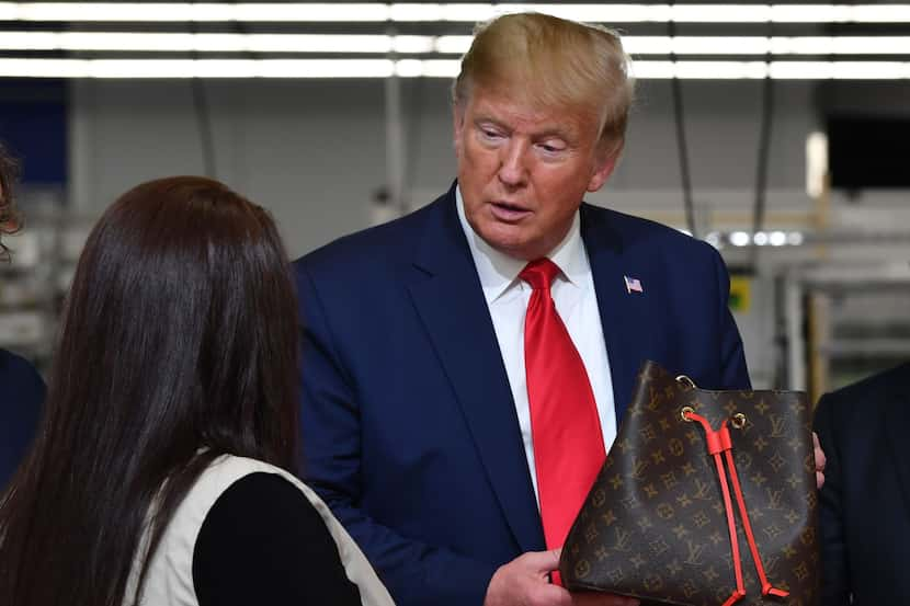 President Donald Trump holds a bag during an October visit to the Louis Vuitton factory in...