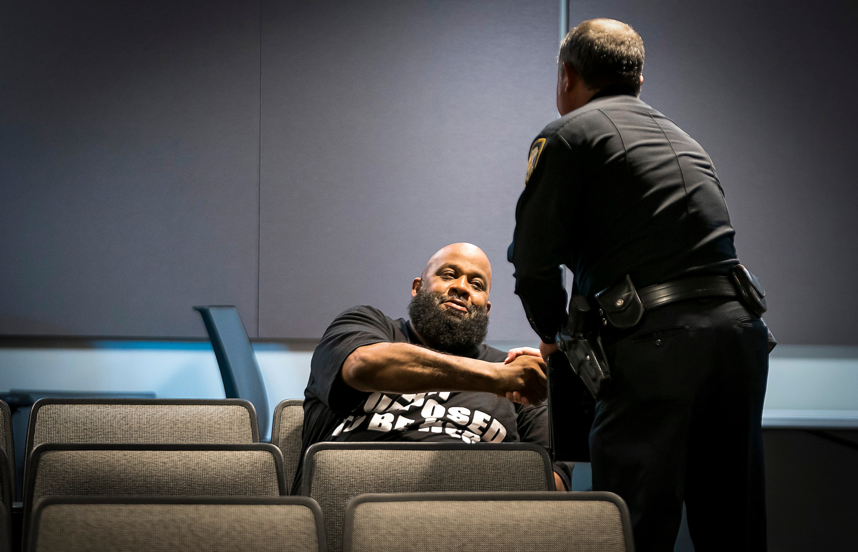 Fort Worth police Lt. Brandon OÕNeil shakes hands with Roger Foggle after addressing a news...