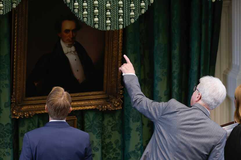 Lt. Gov. Dan Patrick points to the portrait of Stephen F. Austin that hangs over the dais...