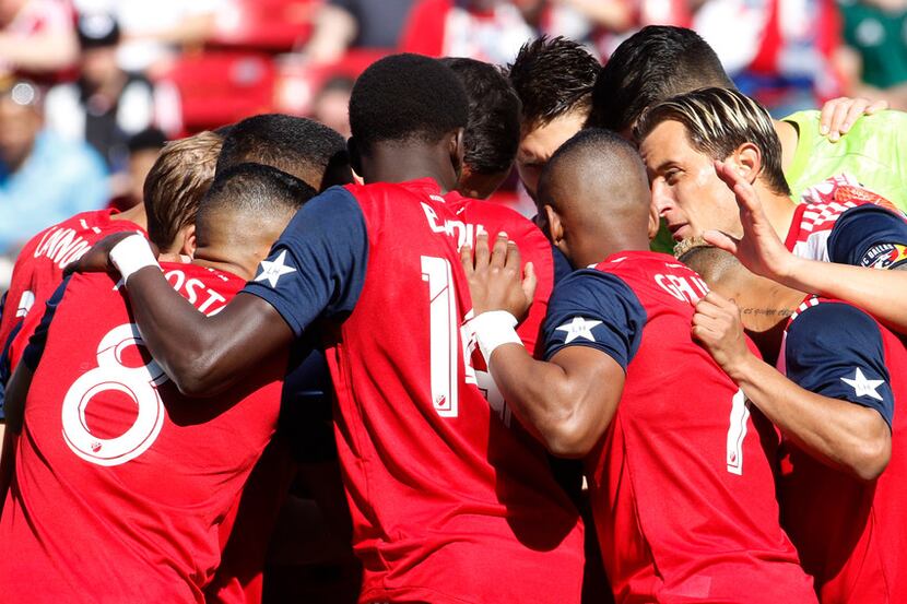 FC Dallas defender Reto Ziegler (3), right, shares a message with teammates just before the...