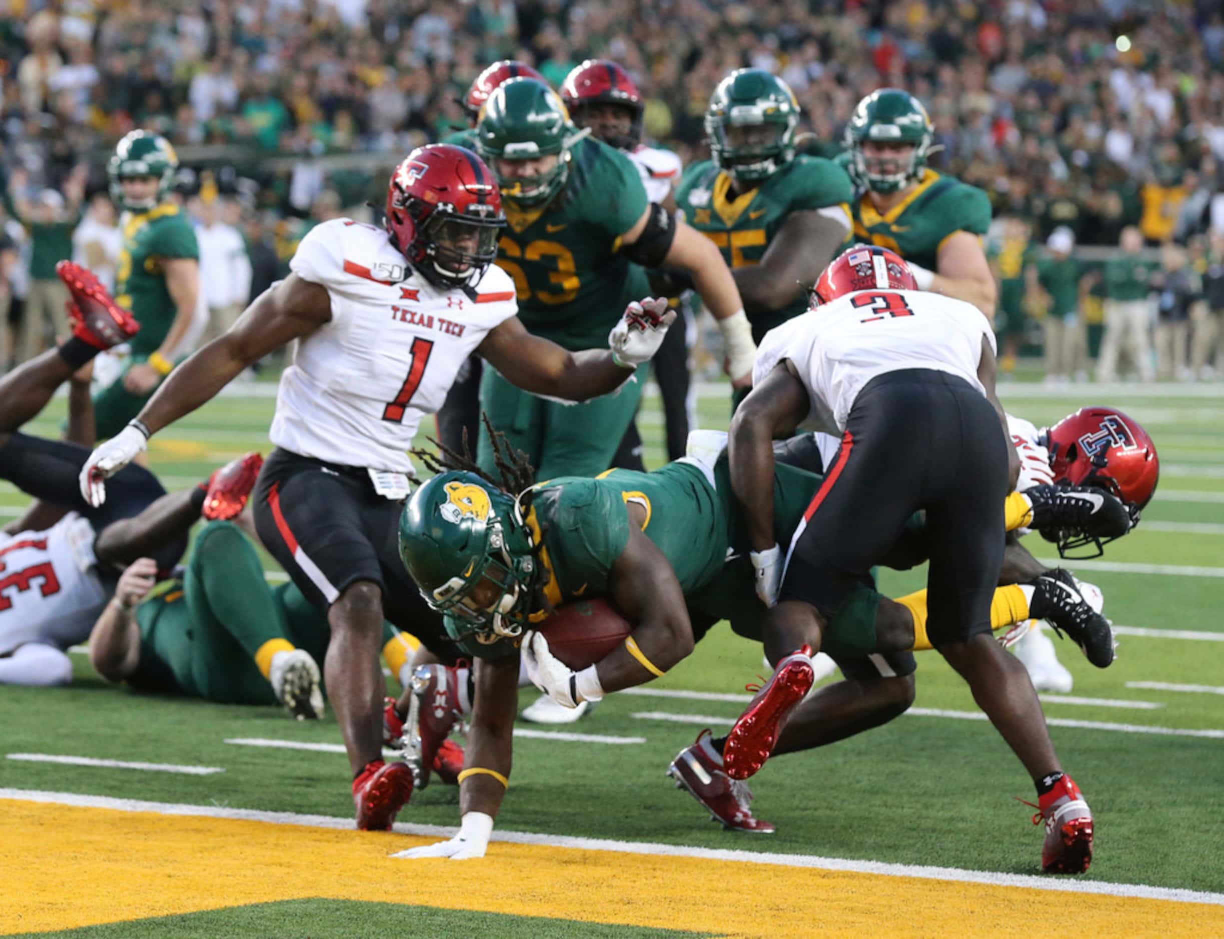 Baylor running back JaMycal Hasty, center, scores the game winning touchdown in overtime...