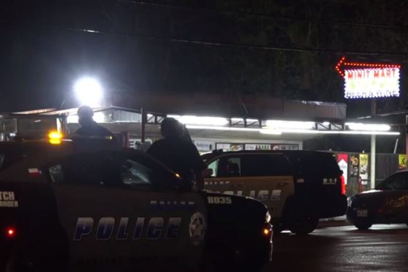Dallas police converge on a convenience store near where shots were fired Tuesday night in...