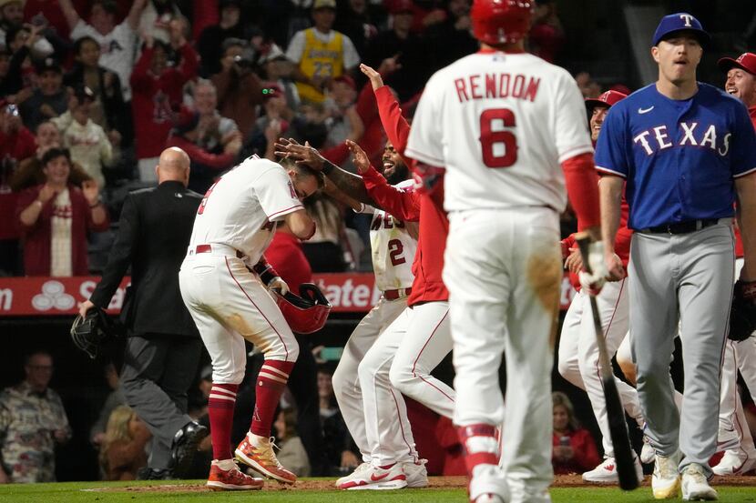 Los Angeles Angels' Zach Neto, left, celebrates with teammates after he scored to win the...