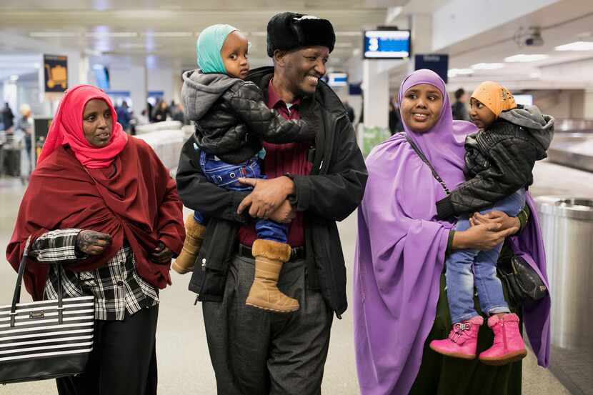 Mohamed lye carries his 2-year old daughter Nafiso, with his wife, Saido Ahmed Abdille,...
