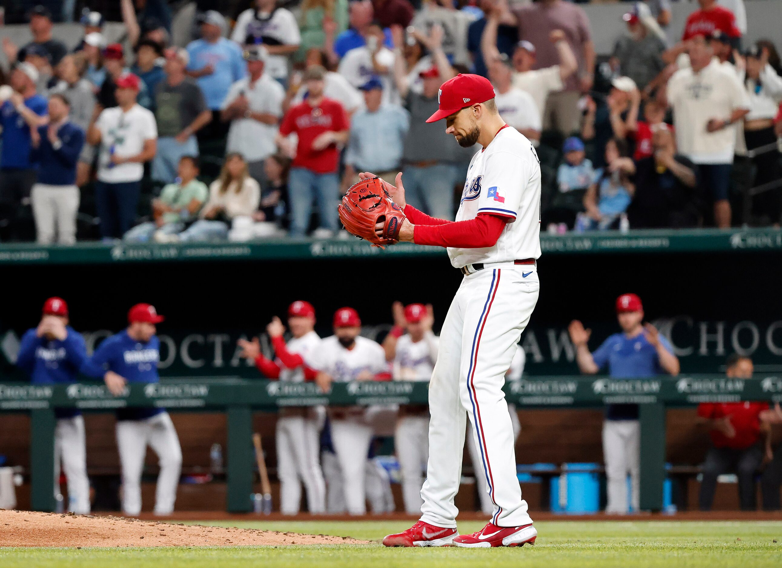 Texas Rangers starting pitcher Nathan Eovaldi (17) reacts after watching the final out of...