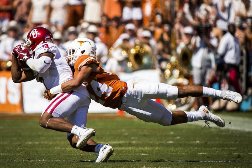 Oklahoma wide receiver Sterling Shepard (3) is brought down by Texas cornerback John Bonney...
