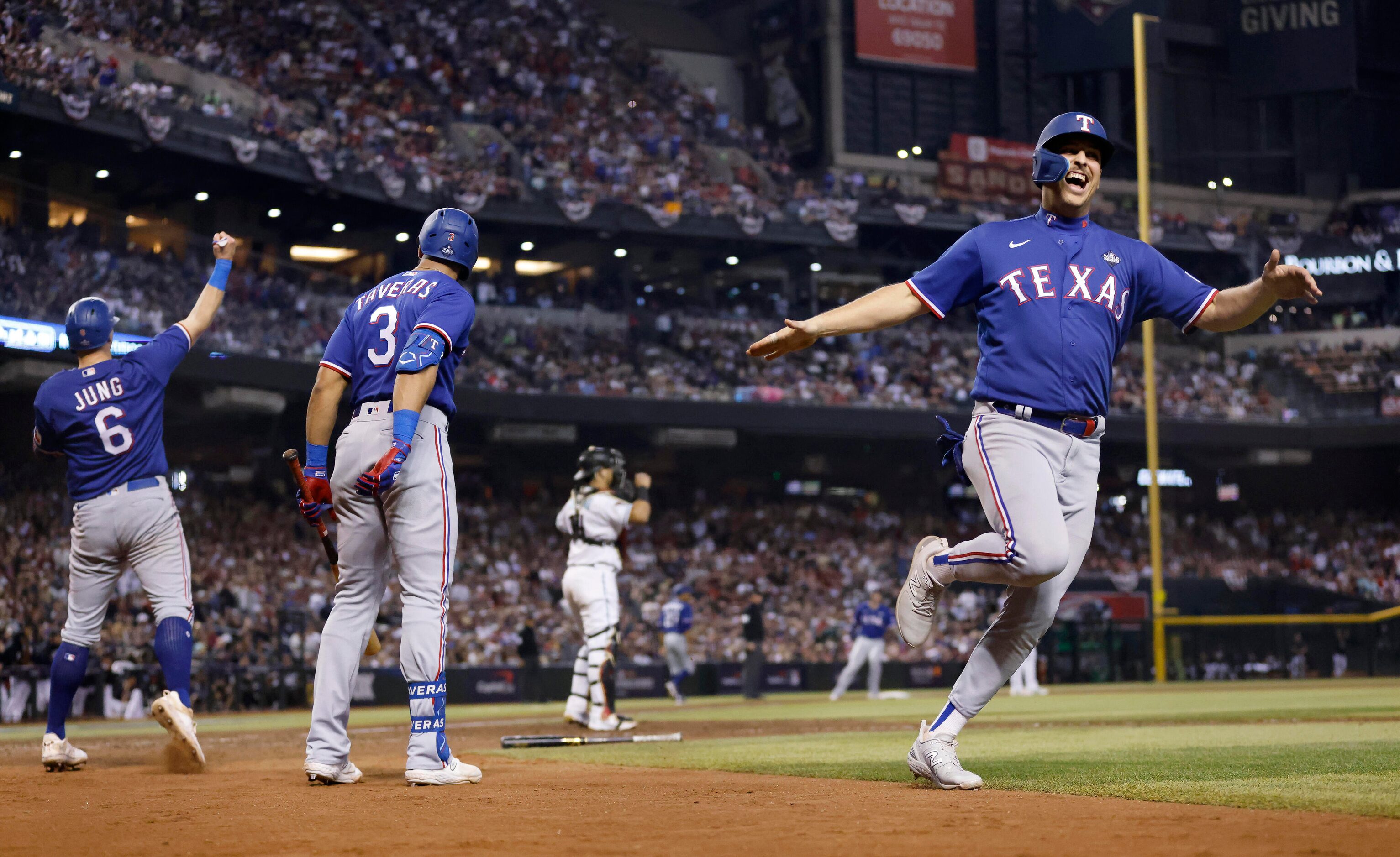 Texas Rangers first baseman Nathaniel Lowe, right, scores on a single hit by Jonah Heim,...