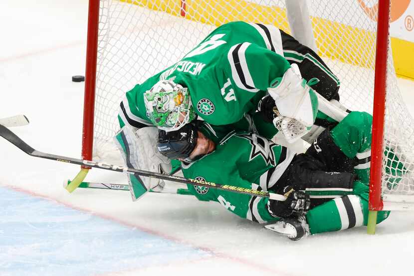 Dallas Stars defenseman Miro Heiskanen (4) slides into goaltender Scott Wedgewood (41)...