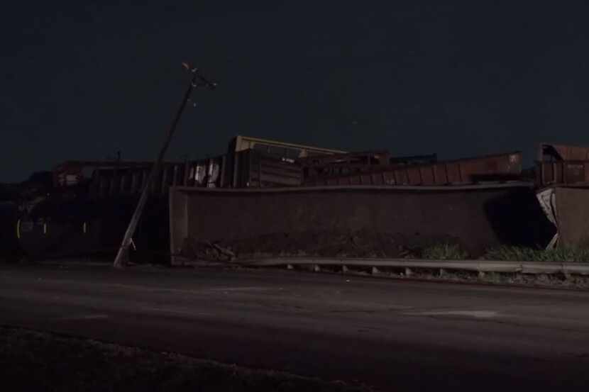 Train cars lie dislodged along Main Street in Fort Worth after a derailment Wednesday morning.