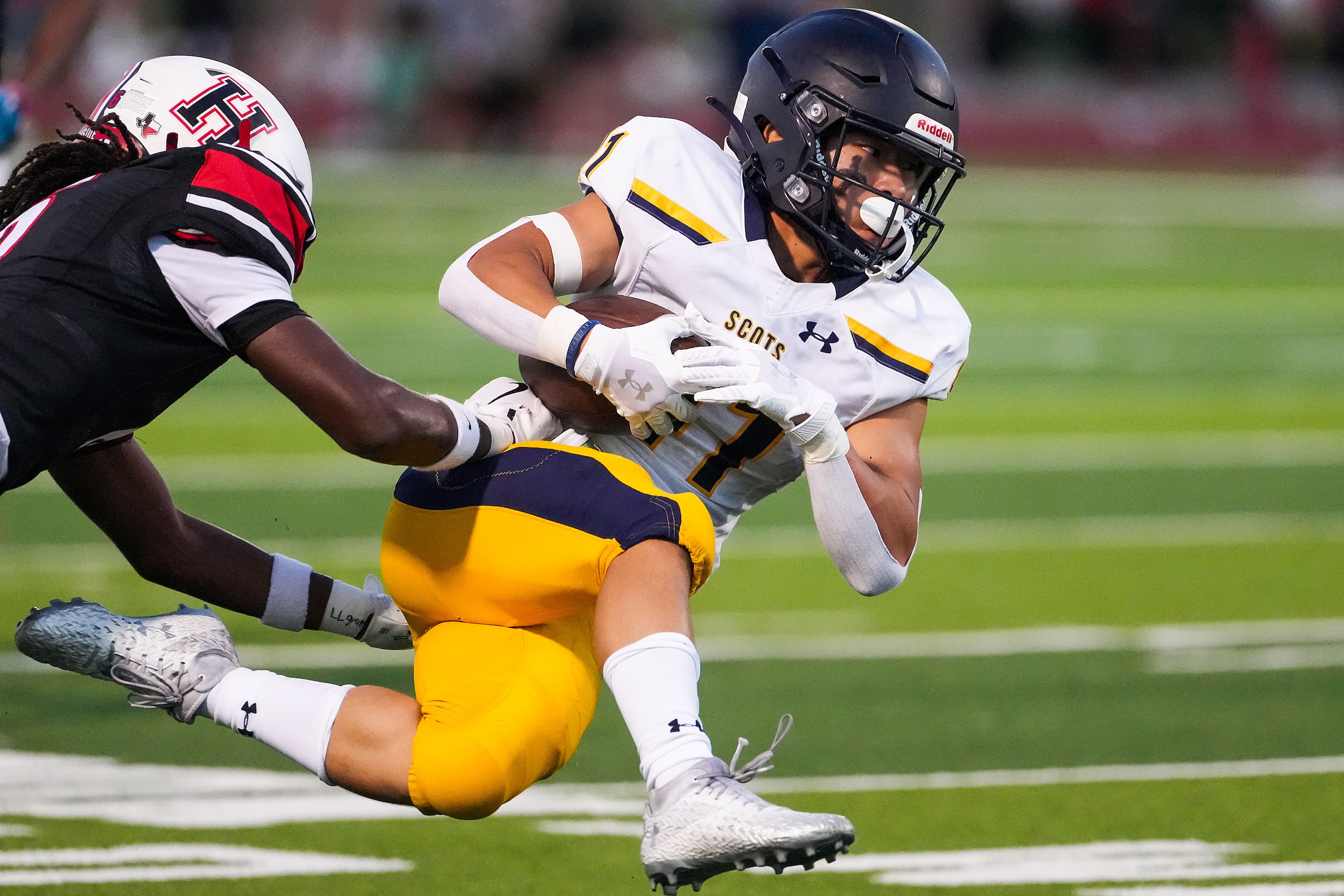 Highland Park running back Isaiah Lee (41) is knocked off his feet by Rockwall-Heath...