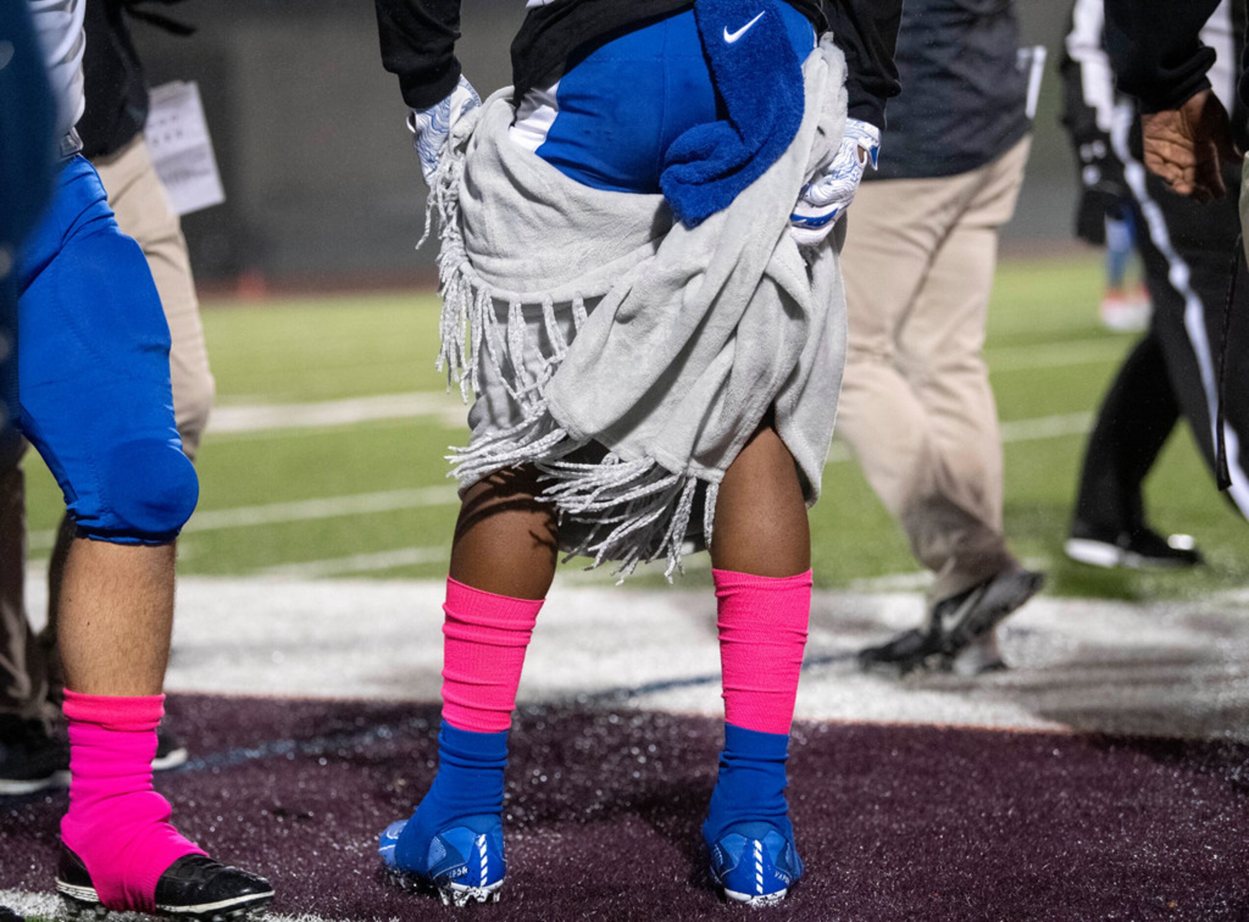 Seagoville senior running back Daelove Harris (20) wraps himself in a blanket to keep warm...