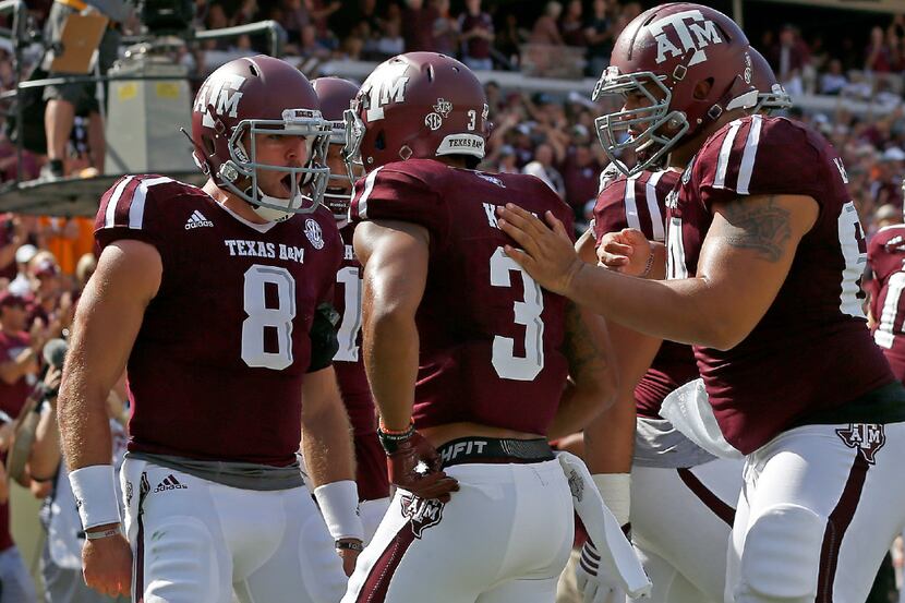 Texas A&M wide receiver Christian Kirk (3) is congratulated by quarterback Trevor Knight (8)...