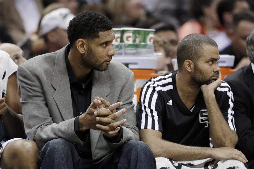San Antonio Spurs'  Tim Duncan, left, who did not play, and Tony Parker, right, of France,...