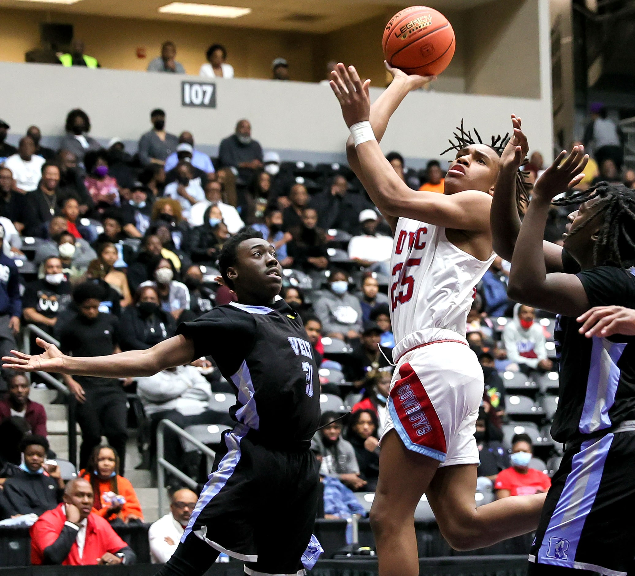 Carter guard Kole Williams (25) puts up a shot over Roosevelt forward Eric Raymond (21) and...