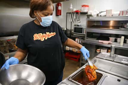 Wanda Marshall of 2Neighbors Hot Chicken in DeSoto dips a chicken breast into OG Sauce for...