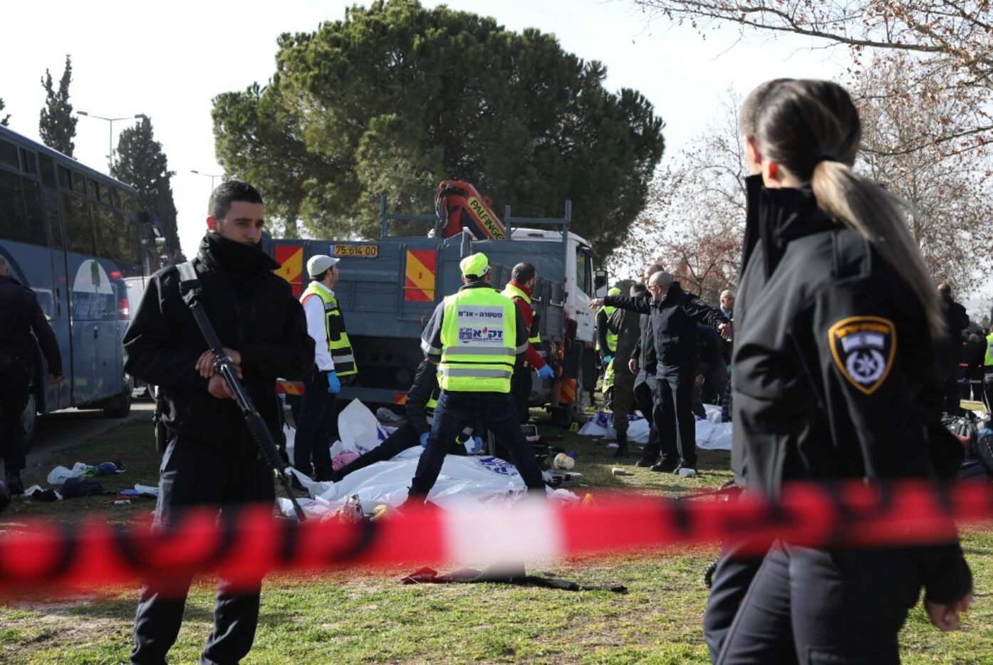 Israeli Zaka volunteers examine a body of one of the four Israeli soldiers killed when a...