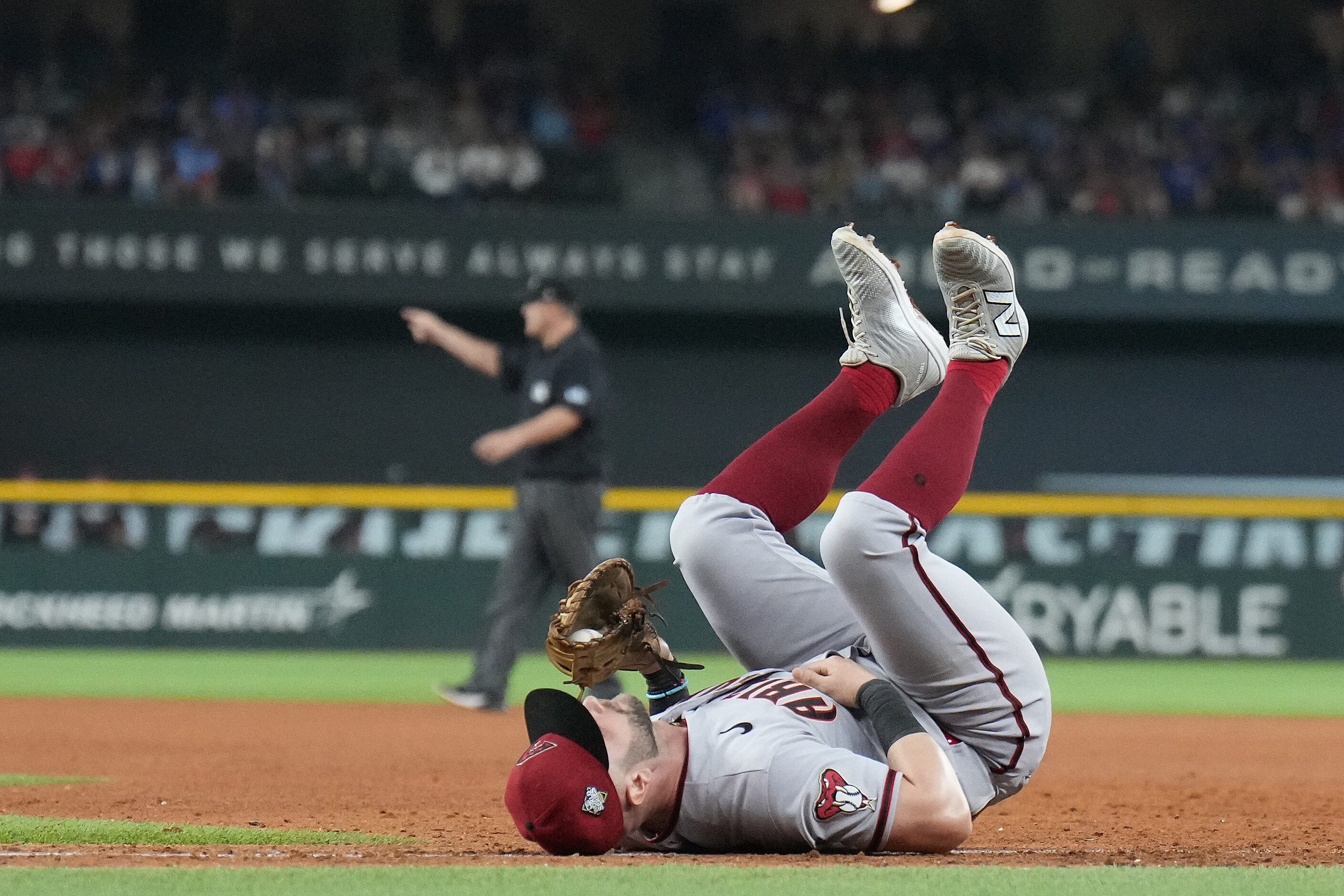 Arizona Diamondbacks first baseman Christian Walker falls to the ground after making the out...